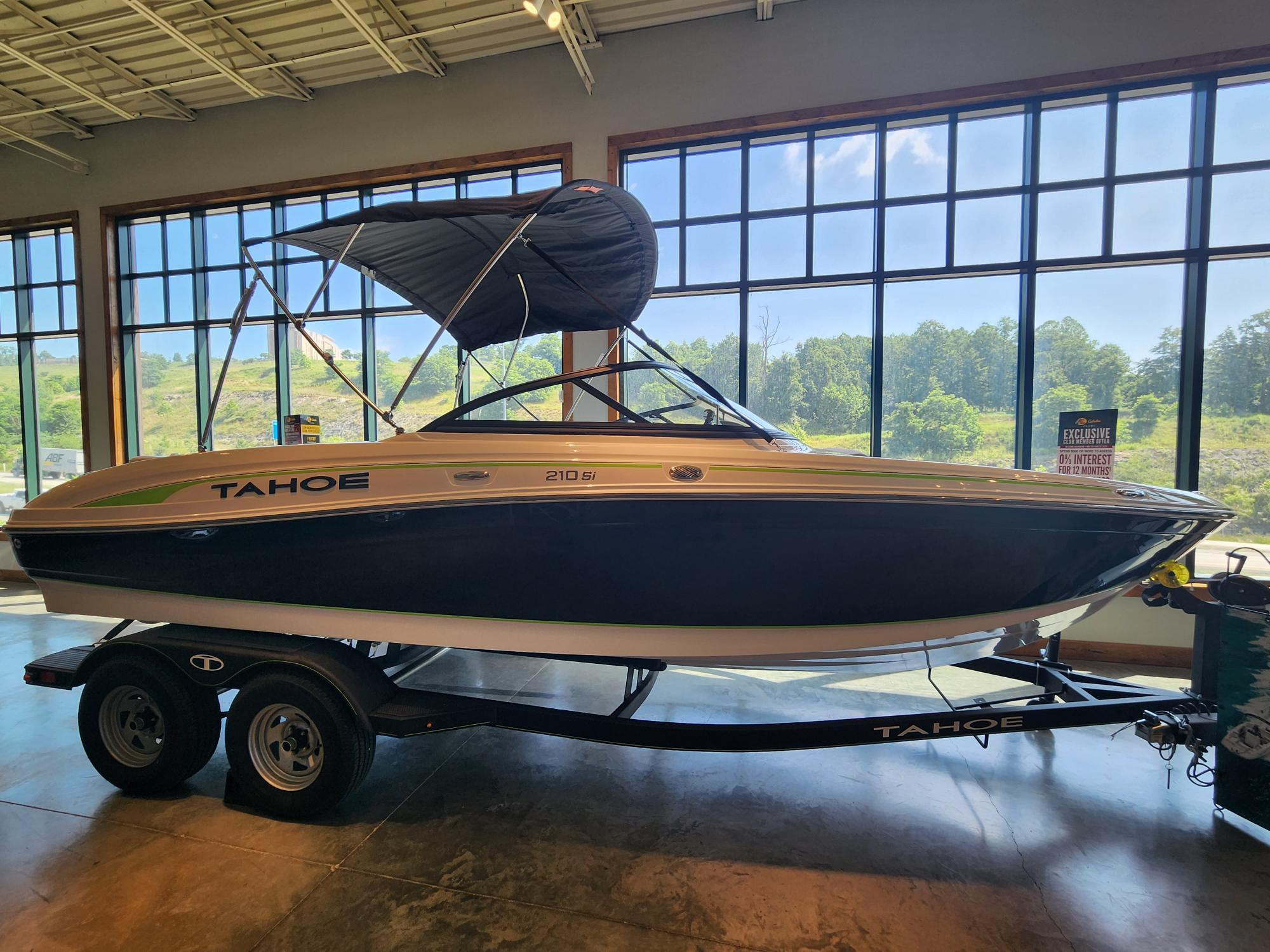 Tahoe 210 Si 2024 Tahoe 210 Si boat displayed indoors with a trailer, large windows in the background.