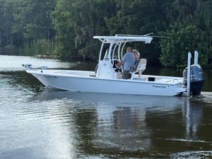 Tidewater 2410 Bay Max 2021 Tidewater 2410 Bay Max boat cruising on a calm river with lush greenery.