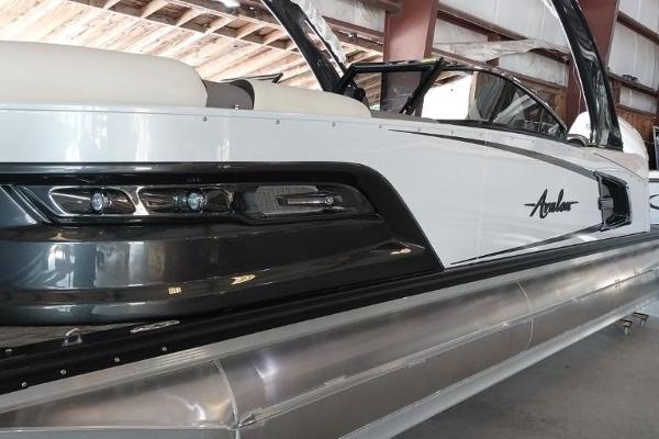 Avalon Excalibur Quad Lounge Windshield 2023 Avalon Excalibur Quad Lounge Windshield pontoon boat in a showroom.