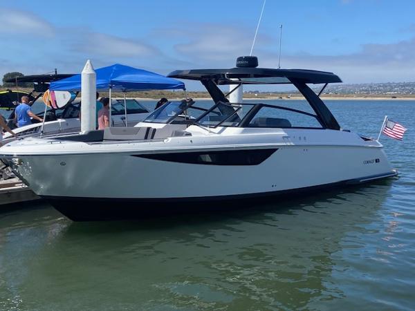 Cobalt R35 2025 Cobalt R35 boat docked on calm water with people nearby.