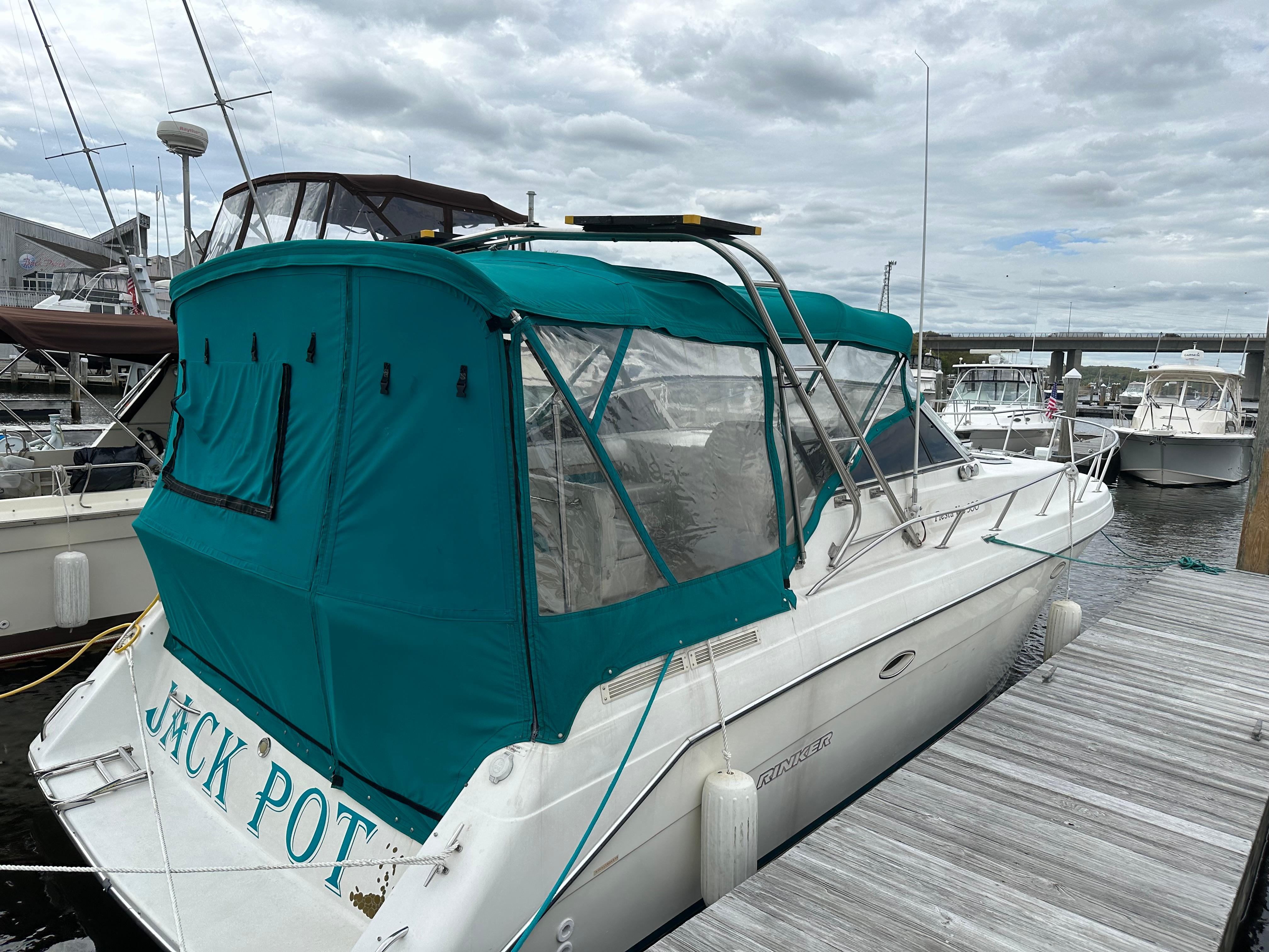 Rinker 300 Fiesta Vee 1996 Rinker 300 Fiesta Vee boat docked with teal canopy and clear windows.