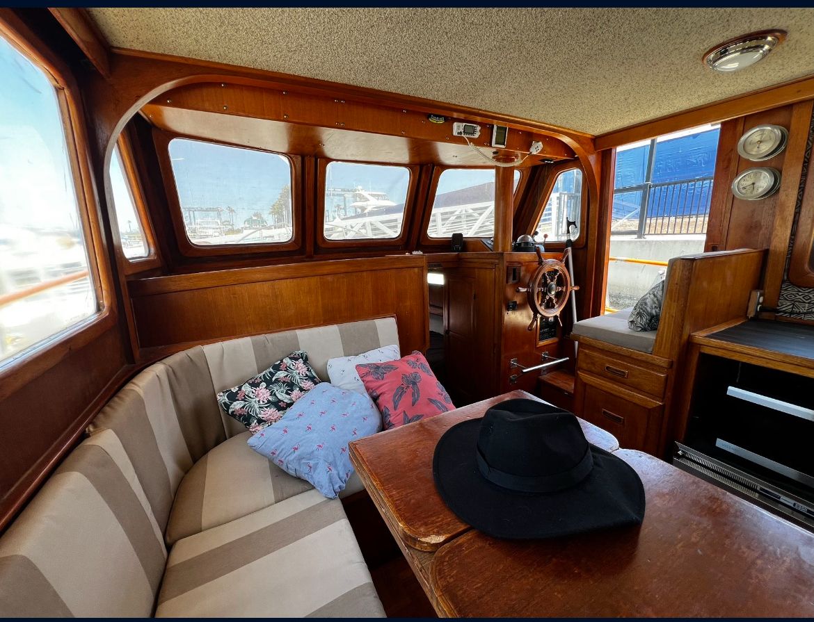 CHB Troller Interior of a 1977 CHB Troller boat with wooden furnishings and cozy seating area.