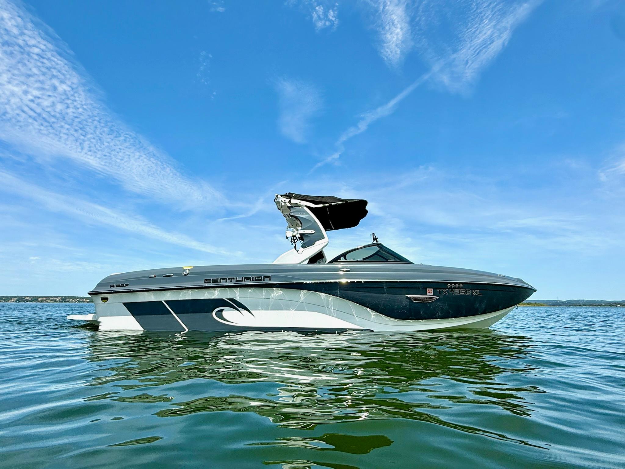 Centurion Ri237 2017 Centurion Ri237 boat on calm water under a clear blue sky.