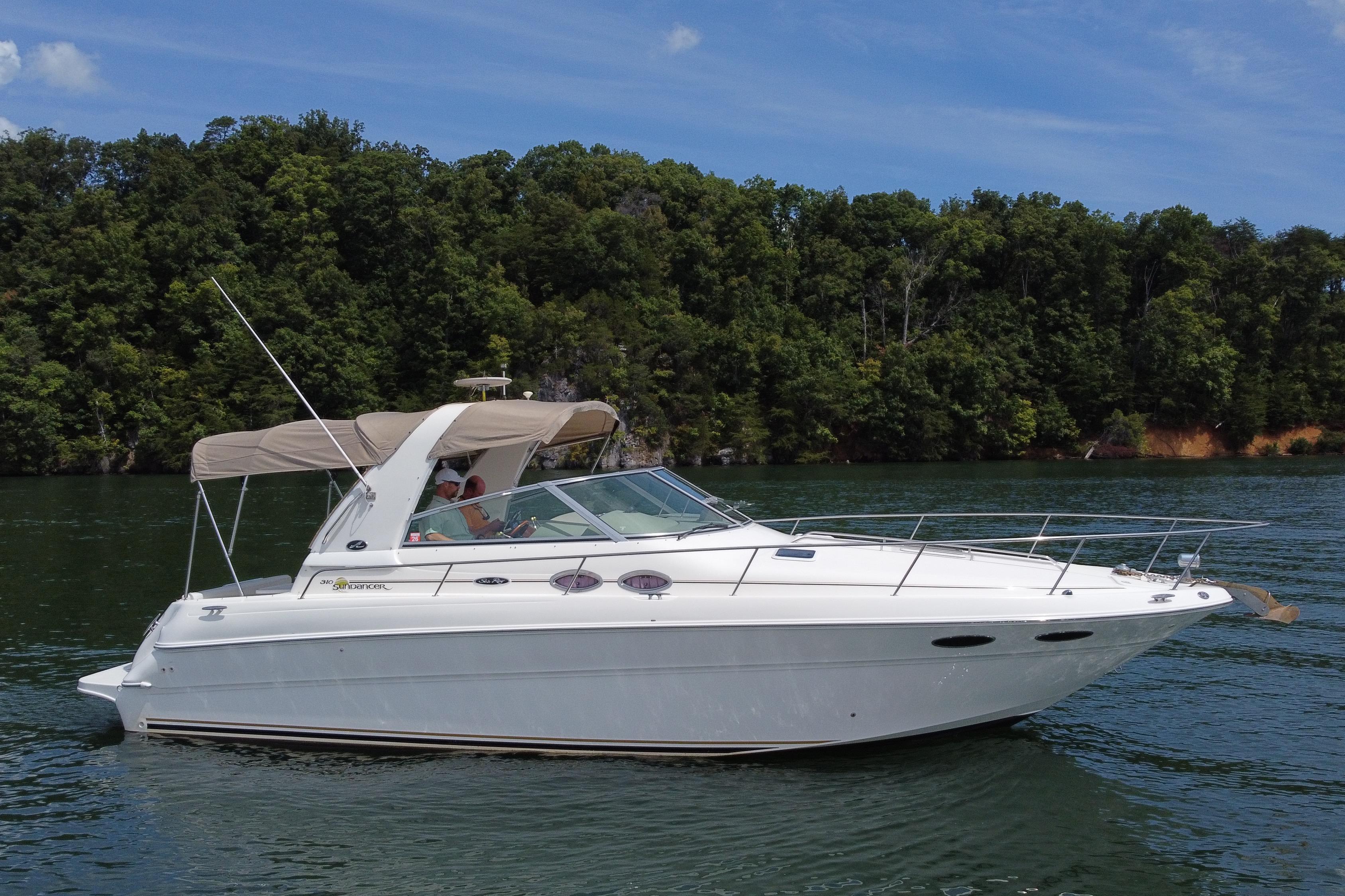 Sea Ray 310 Sundancer 2001 Sea Ray 310 Sundancer cruising on a serene lake with lush forest backdrop.
