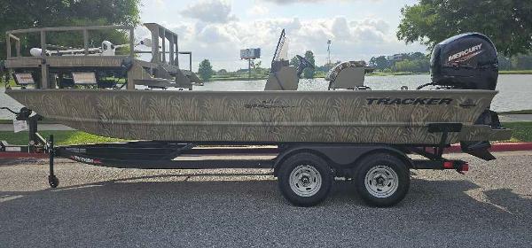 Tracker Grizzly 2072 CC Sportsman 2024 Tracker Grizzly 2072 CC Sportsman boat on trailer by a lake.