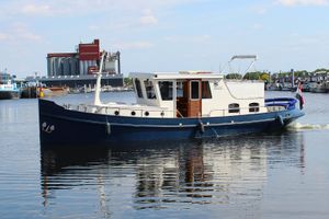 Motor Yacht Ex Sleepboot Historic 1916 Motor Yacht Ex Sleepboot cruising on a calm waterway.
