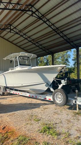 Sea Hunt Gamefish 30 Forward Seating 2024 Sea Hunt Gamefish 30 boat on trailer under metal canopy.