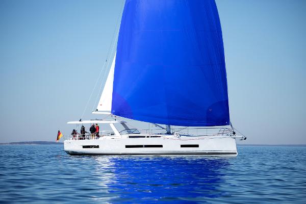 Hanse 590 2025 Hanse 590 yacht with blue sail on calm sea.