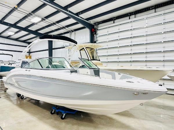Chaparral 23 SSi OB 2025 Chaparral 23 SSi OB boat in a showroom, sleek design, white and gray color.