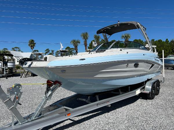 Crownline Eclipse E290 XS 2024 Crownline Eclipse E290 XS boat on trailer, sunny day, palm trees in background.