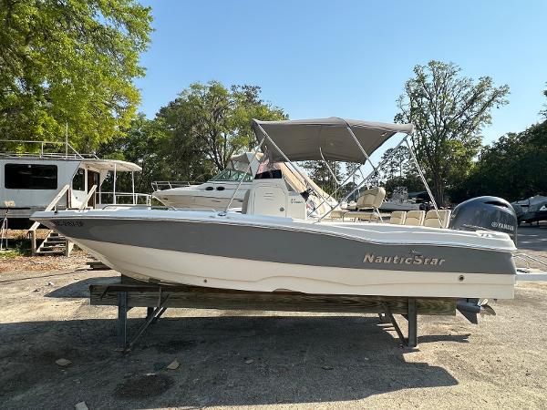 NauticStar 211 Hybrid 2021 NauticStar 211 Hybrid boat with canopy, parked outdoors on a sunny day.