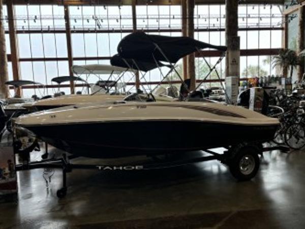 Tahoe T16 2024 Tahoe T16 boat displayed indoors with canopy and trailer.