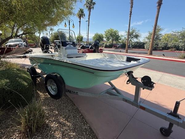 Mako Pro Skiff 15 CC 2025 Mako Pro Skiff 15 CC boat on trailer, parked outdoors with palm trees.