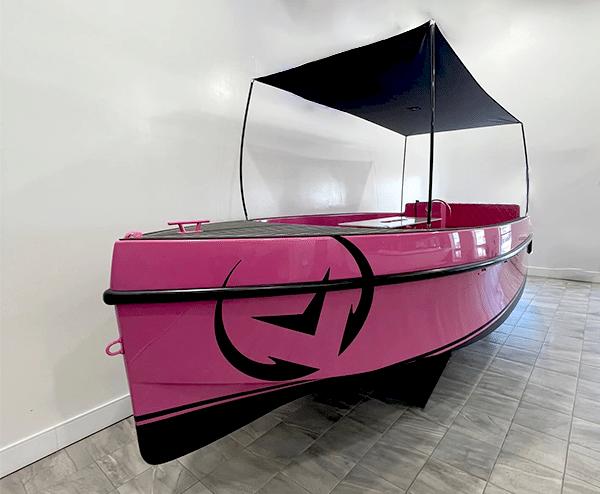 Vision Marine Technologies Volt 180 2023 Vision Marine Technologies Volt 180, pink electric boat with canopy, displayed indoors.