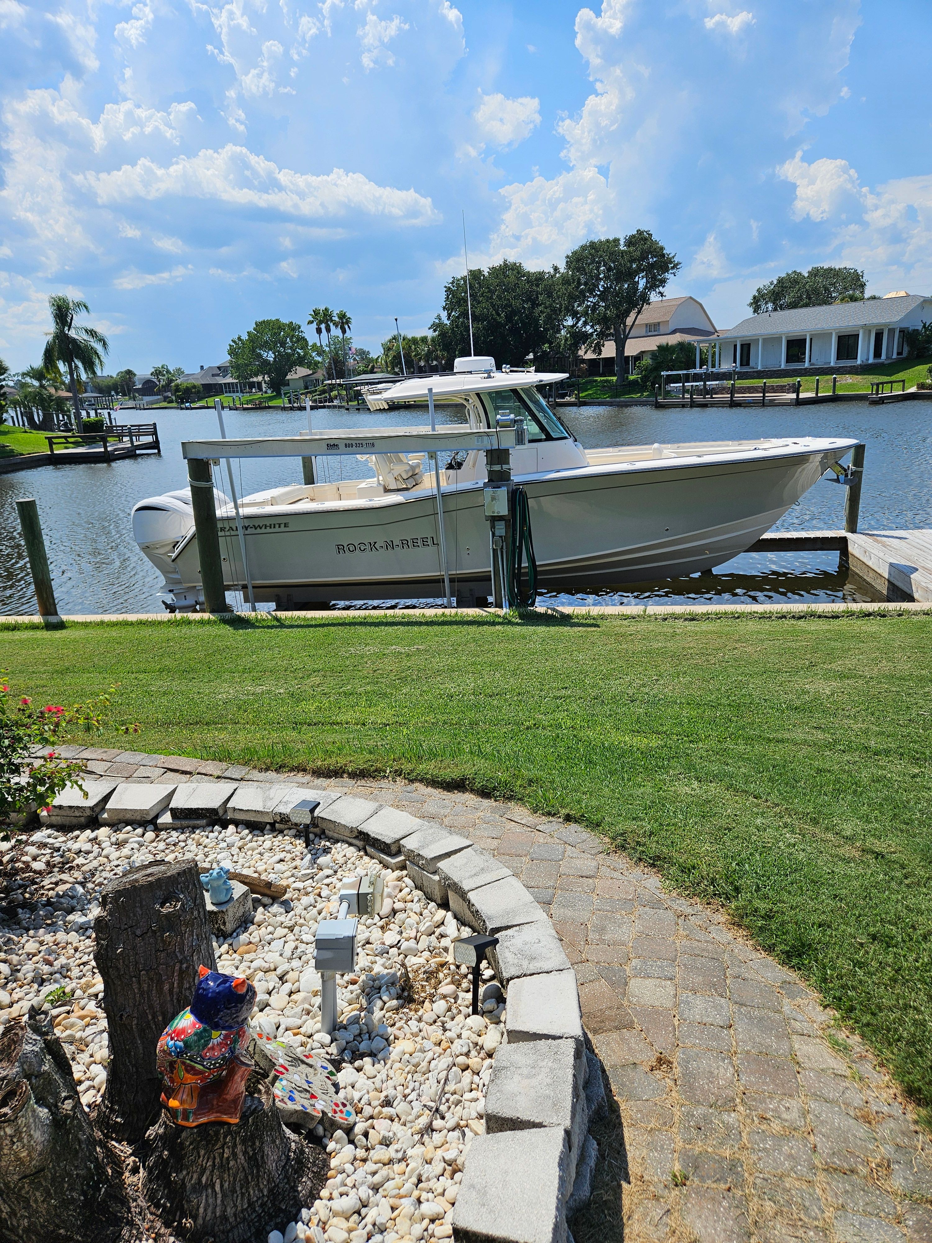 Grady-White Canyon 336 2022 Grady-White Canyon 336 boat docked by a scenic waterfront garden.