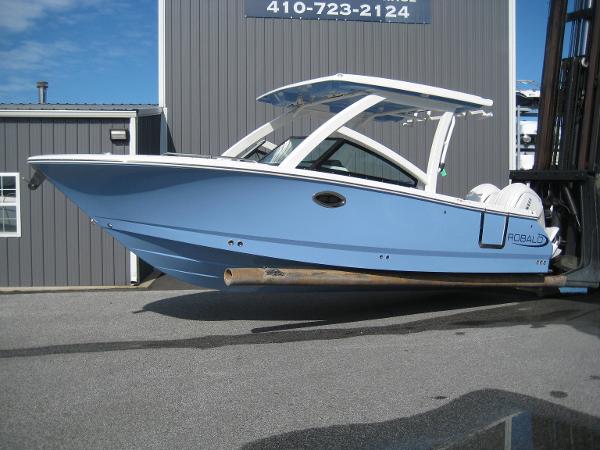 Robalo R257 2025 Robalo R257 boat in light blue, displayed outdoors near a building.