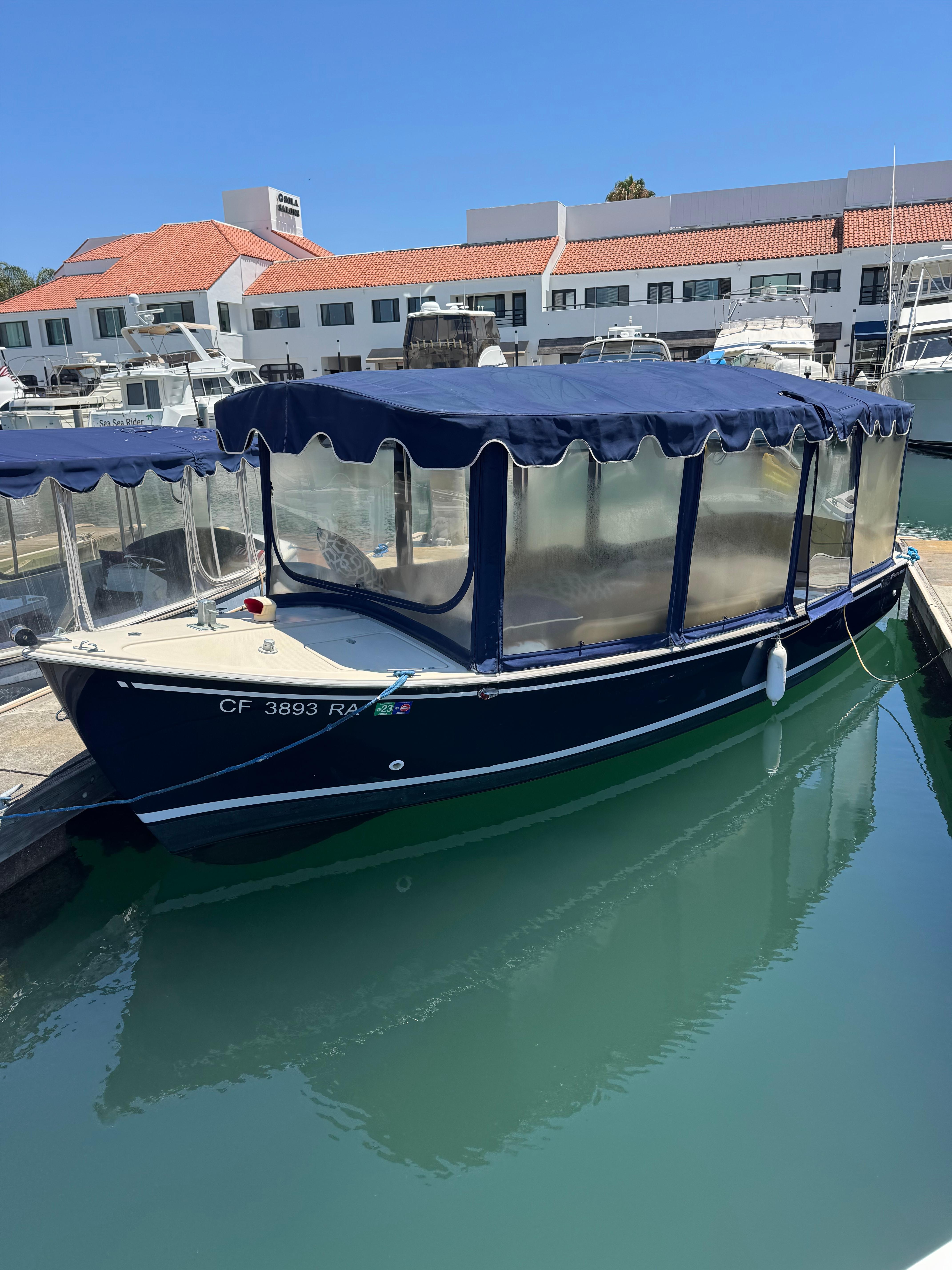 Duffy Newporter 2004 Duffy NEWPORTER boat docked in marina with blue canopy and clear side panels.