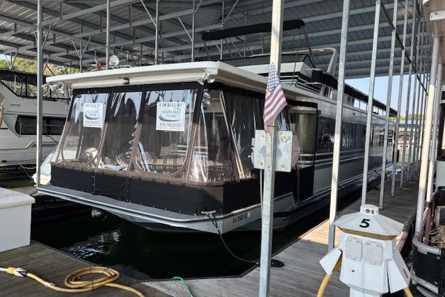 Sumerset 14x71 1989 Sumerset 14x71 houseboat docked, covered, with "For Sale" signs displayed.