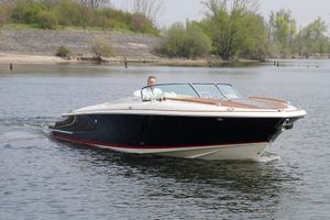 Chris-Craft Corsair 34 2022 Chris-Craft Corsair 34 cruising on a calm river with lush greenery.