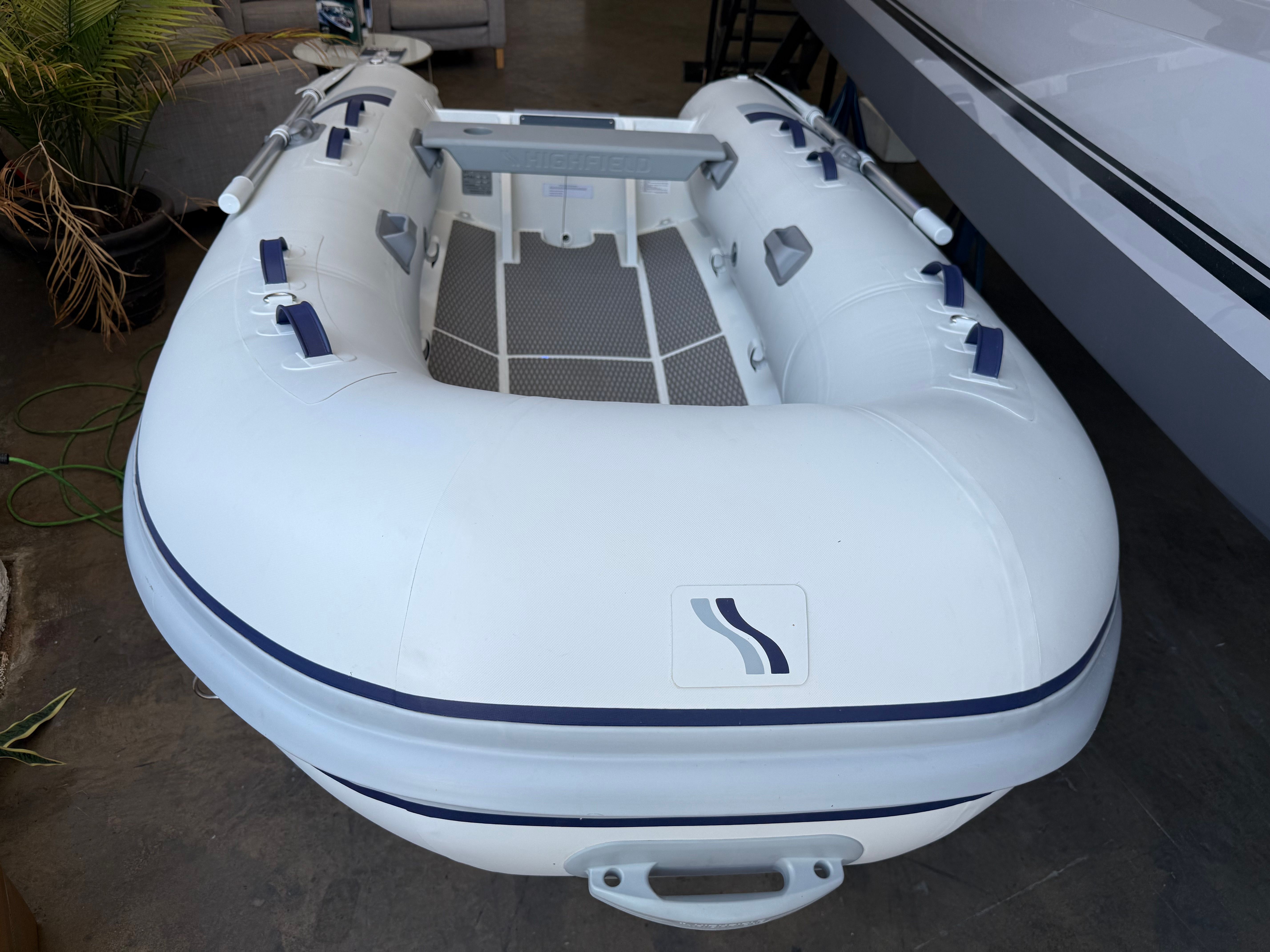 Highfield Ultra Lite 310FD 2024 Highfield Ultra Lite 310FD inflatable boat, white with blue accents, displayed indoors.