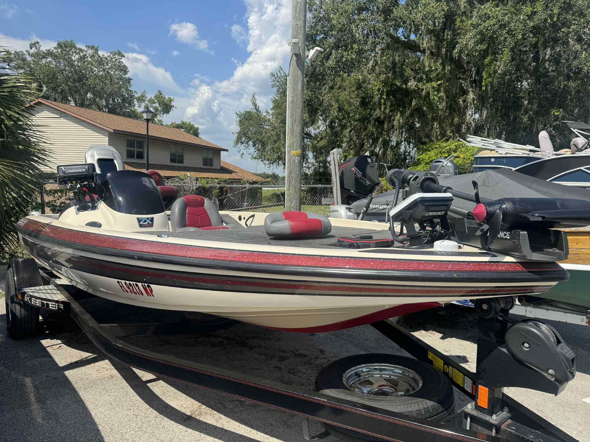 Skeeter ZX 190 2007 Skeeter ZX 190 boat with red accents, parked on a trailer under a sunny sky.