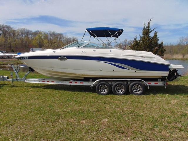 Chaparral 280 SSi 2001 Chaparral 280SSi boat on trailer with blue canopy, parked on grass.