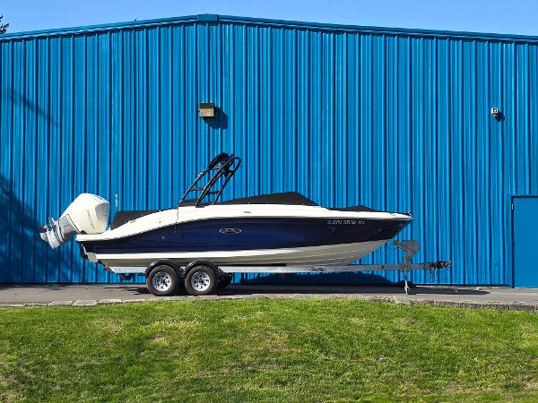 Sea Ray SPX 230 Outboard 2023 Sea Ray SPX 230 Outboard boat on trailer, parked by blue building.