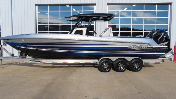 Sunsation 32 CCX 2018 Sunsation 32 CCX boat on trailer, sleek design, blue and silver accents.