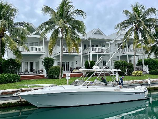 Contender 35 Side Console 2001 Contender 35 Side Console boat docked by waterfront homes with palm trees.