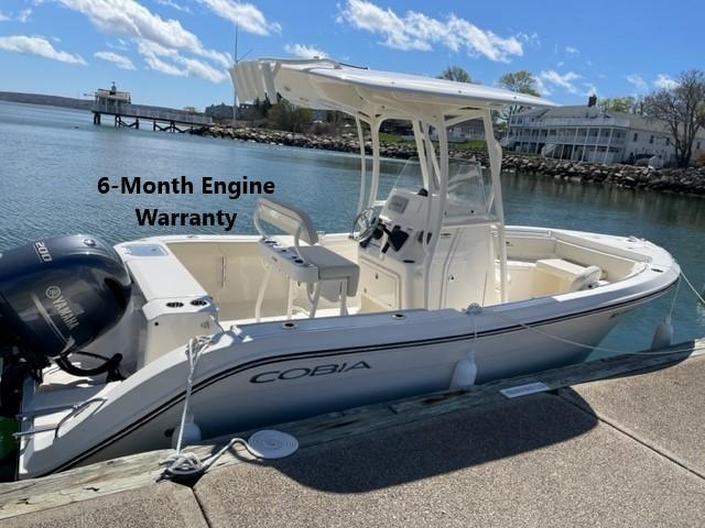 Cobia 220 CC 2023 Cobia 220 CC boat docked, featuring a 6-month engine warranty.