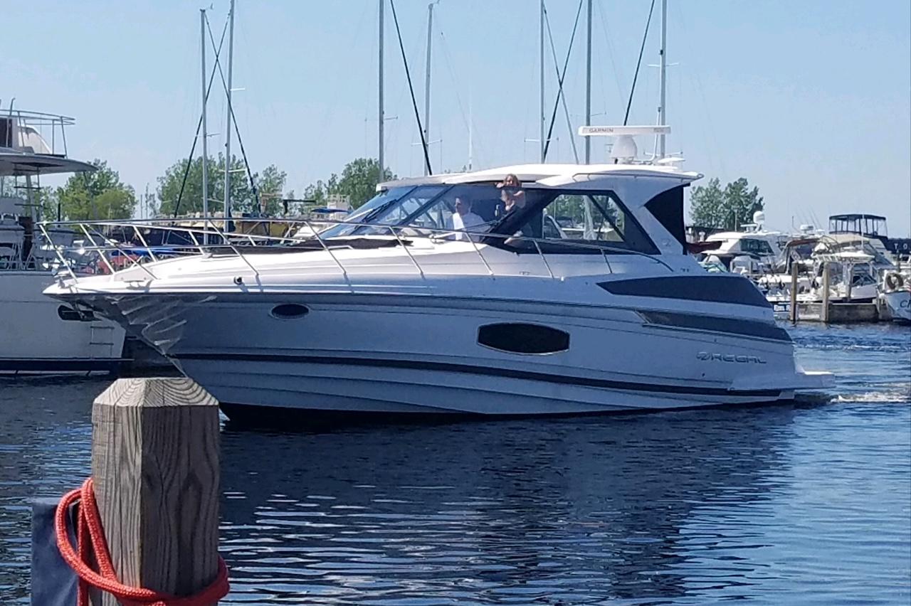 Regal 46 Sport Coupe 2015 Regal 46 Sport Coupe yacht docked in a marina, surrounded by other boats.