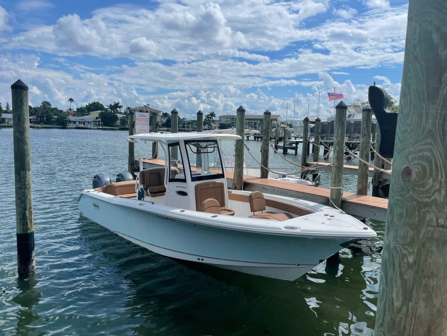 Sea Hunt Ultra 265 SE 2022 Sea Hunt Ultra 265 SE boat docked at marina under blue sky.
