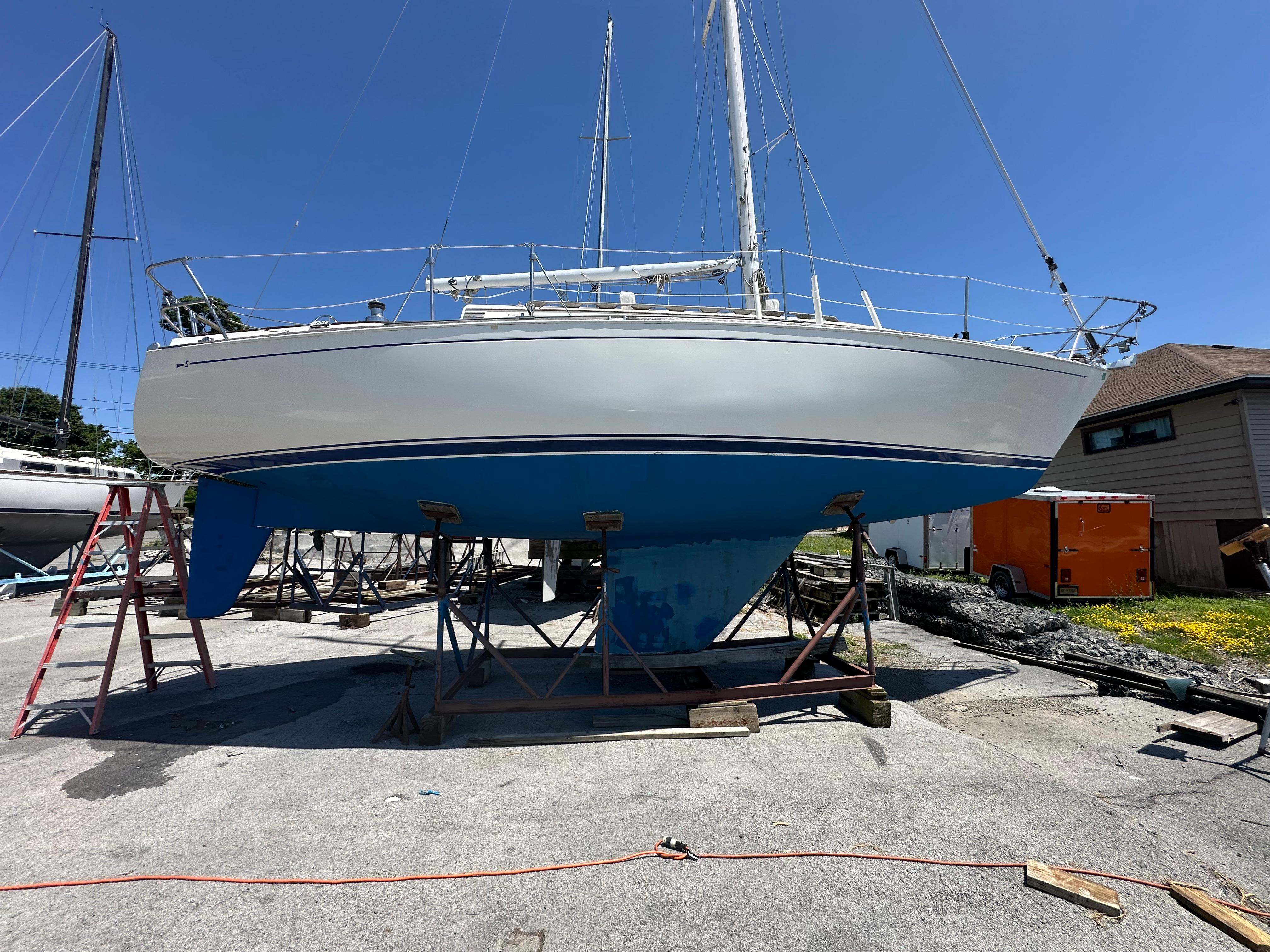 Sabre 32 1986 Sabre 32 sailboat on stands, blue hull, clear sky background.