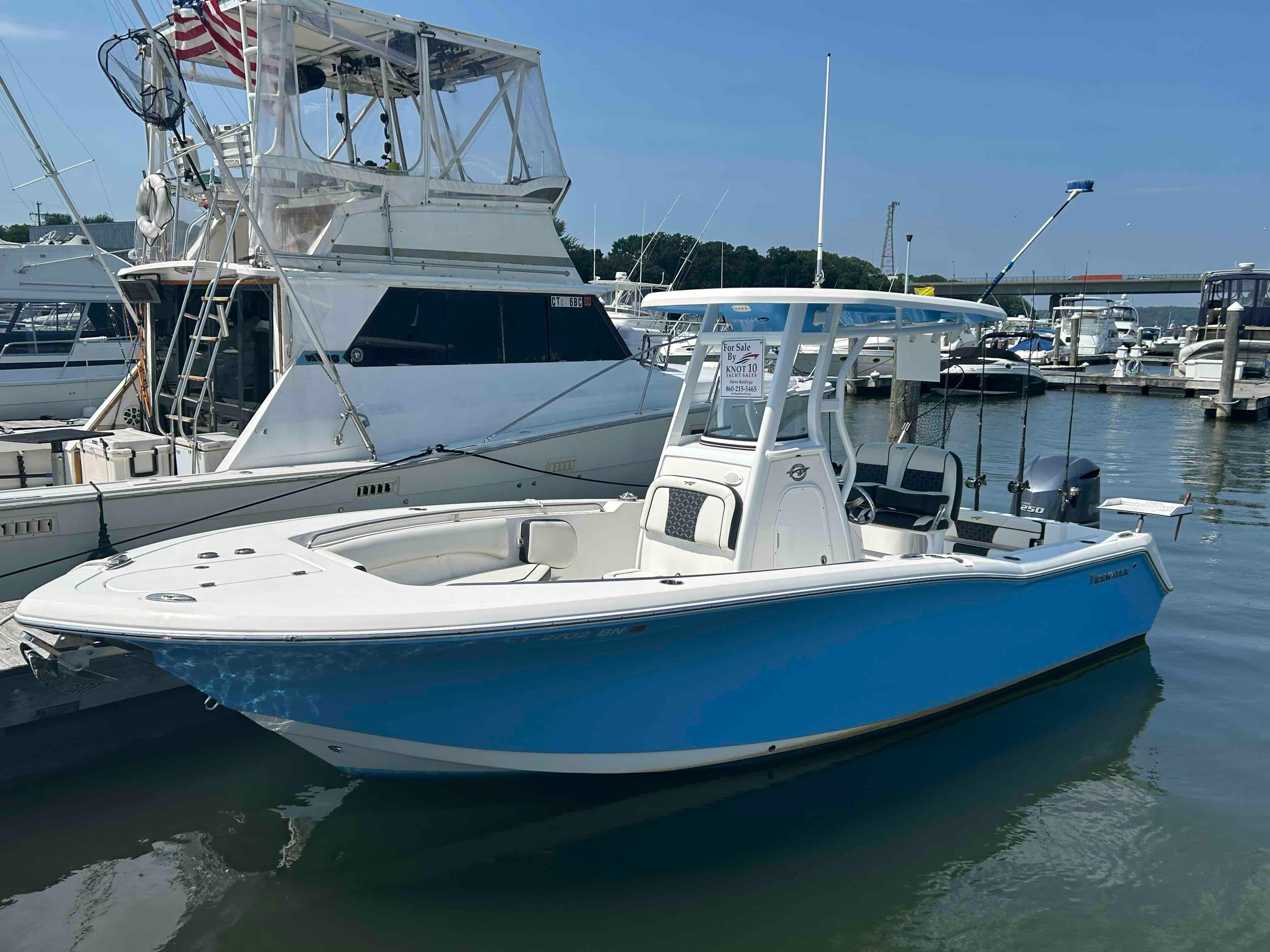Tidewater 232 CC Adventure 2021 Tidewater 232 CC Adventure boat docked at marina, blue hull, clear sky.