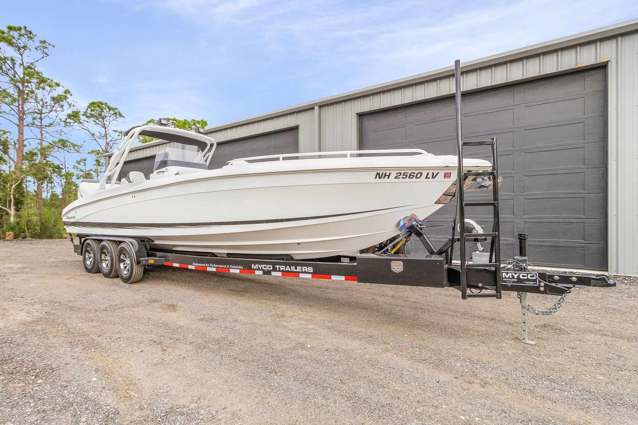 Renegade 32' Cuddy 2020 Renegade 32' Cuddy boat on trailer, parked outside a large garage.