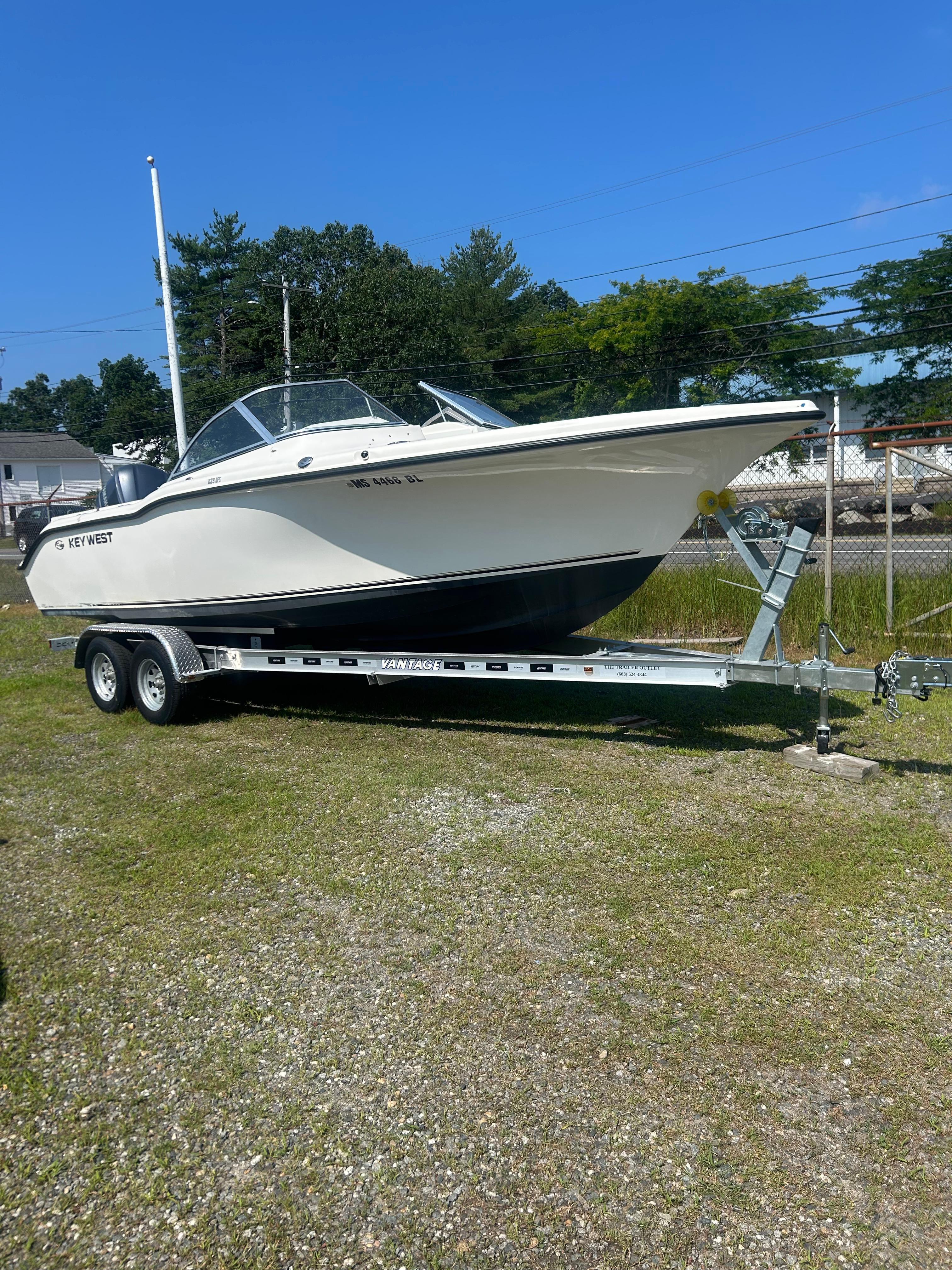 Key West 239 DFS 2022 Key West 239 DFS boat on trailer, parked on grass under clear blue sky.