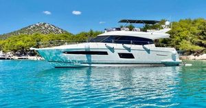 Prestige 550 Luxury 2014 Prestige 550 yacht on turquoise water, surrounded by lush greenery and hills.