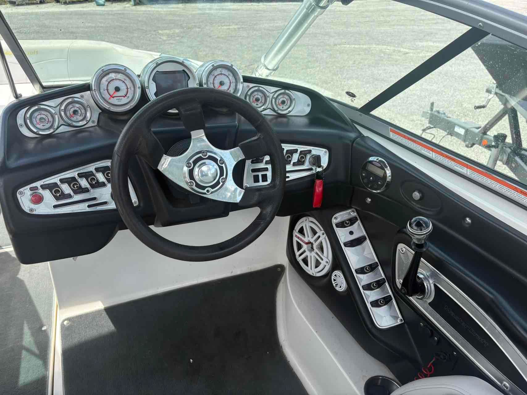 MasterCraft X-45 2008 MasterCraft X-45 boat dashboard with steering wheel and control panel.