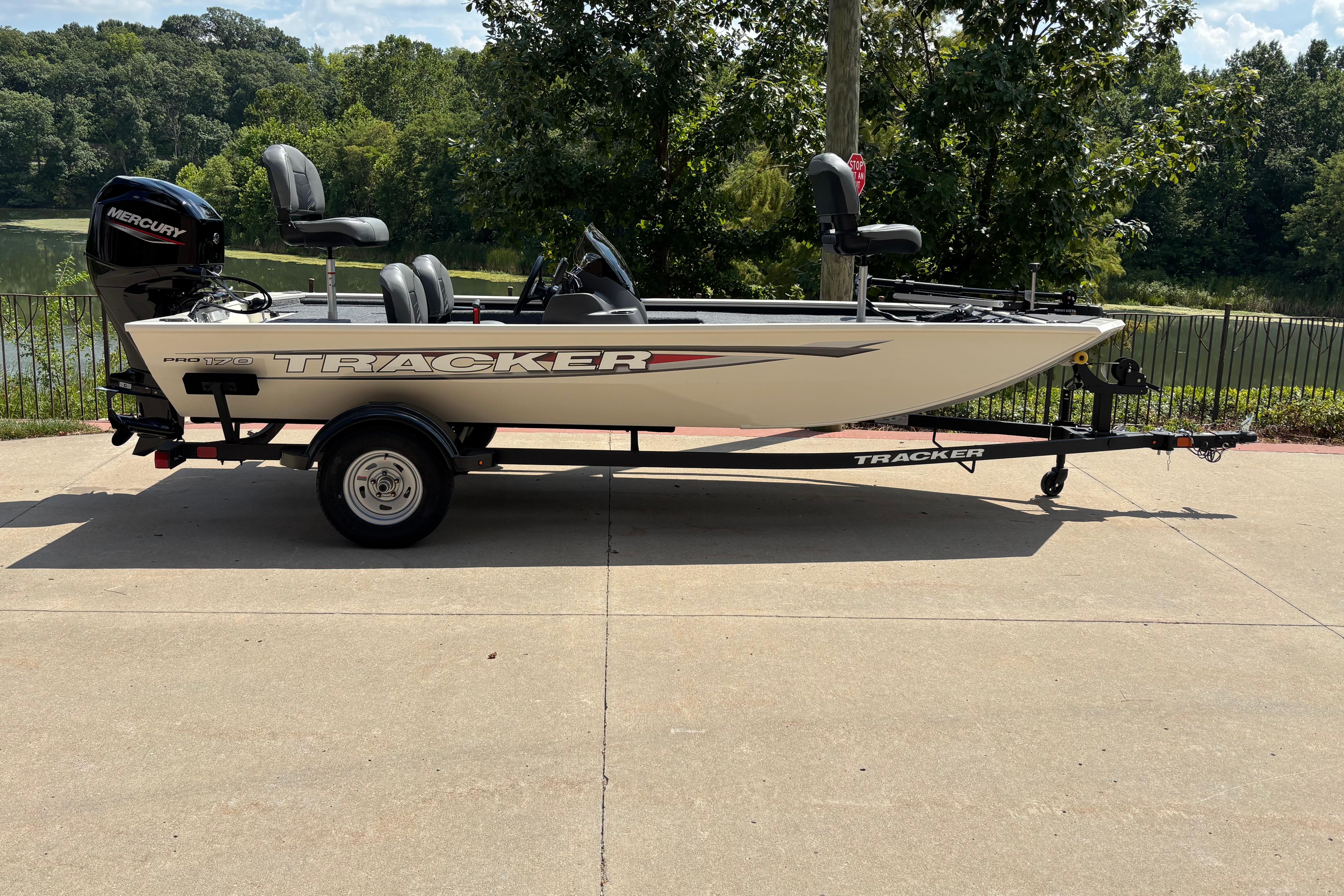 Tracker Pro 170 2026 Tracker Pro 170 boat on trailer, parked near a scenic lake.