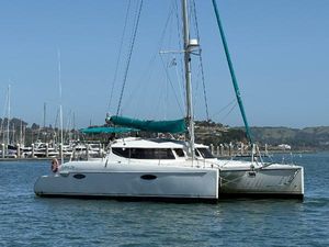 Fountaine Pajot Lavezze 2006 Fountaine Pajot Lavezze catamaran sailing in a marina with clear skies.