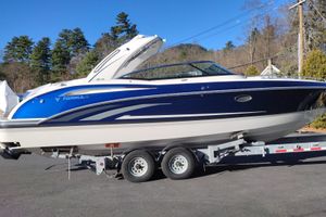 Formula 310 Bowrider 2026 Formula 310 Bowrider boat on trailer, blue and white design, parked outdoors.