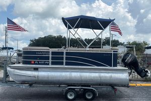 Harris FloteBote Cruiser 180 2014 Harris FloteBote Cruiser 180 pontoon boat on trailer with American flags.