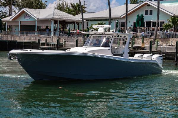Edgewater 370CC 2025 Edgewater 370CC boat cruising near waterfront buildings.