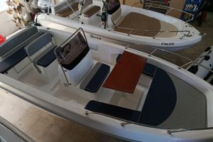 Saver 585 open 2025 Saver 585 Open boat with seating and table in showroom.