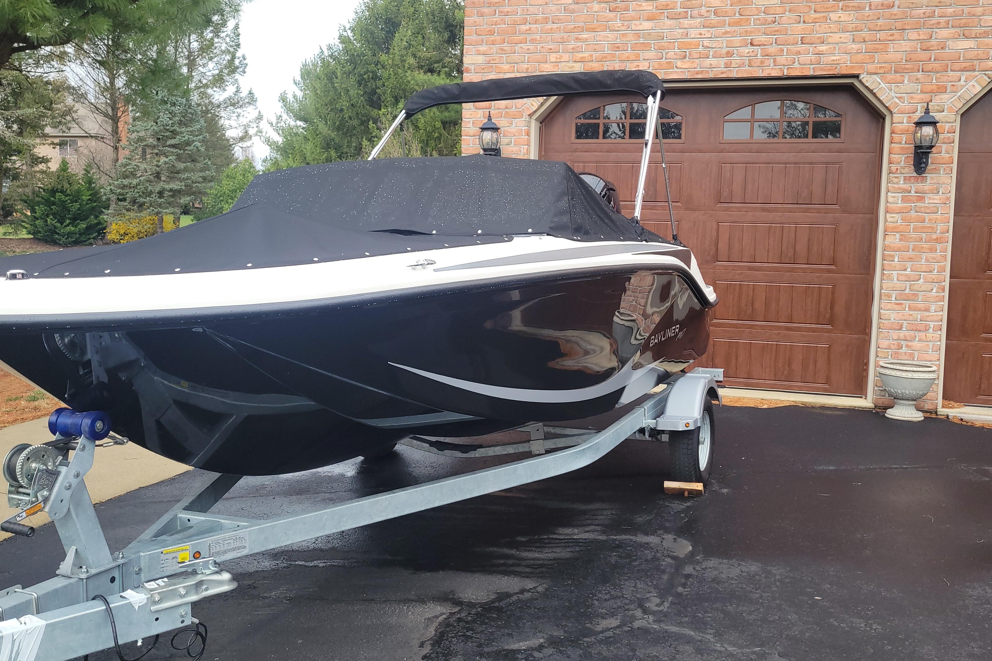 Bayliner Element M17 2025 Bayliner Element M17 boat on trailer, parked in driveway with garage backdrop.