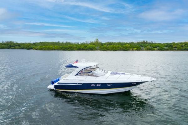 Regal 4260 COMMODORE 2004 Regal 4260 Commodore yacht cruising on a serene lake.