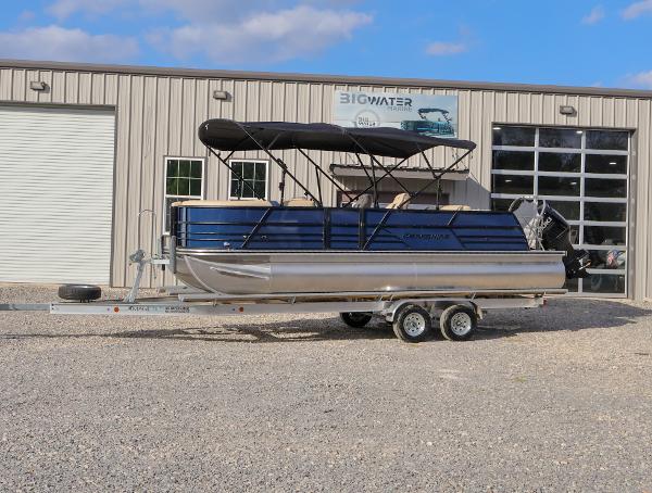Berkshire 24 UL CTS 2024 Berkshire 24 UL CTS pontoon boat on trailer outside a garage.