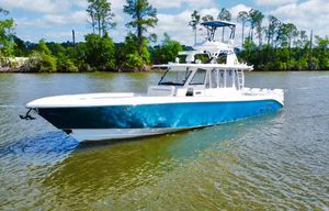 Everglades 435 Center Console 2016 Everglades 435 Center Console boat on a calm river with lush greenery.