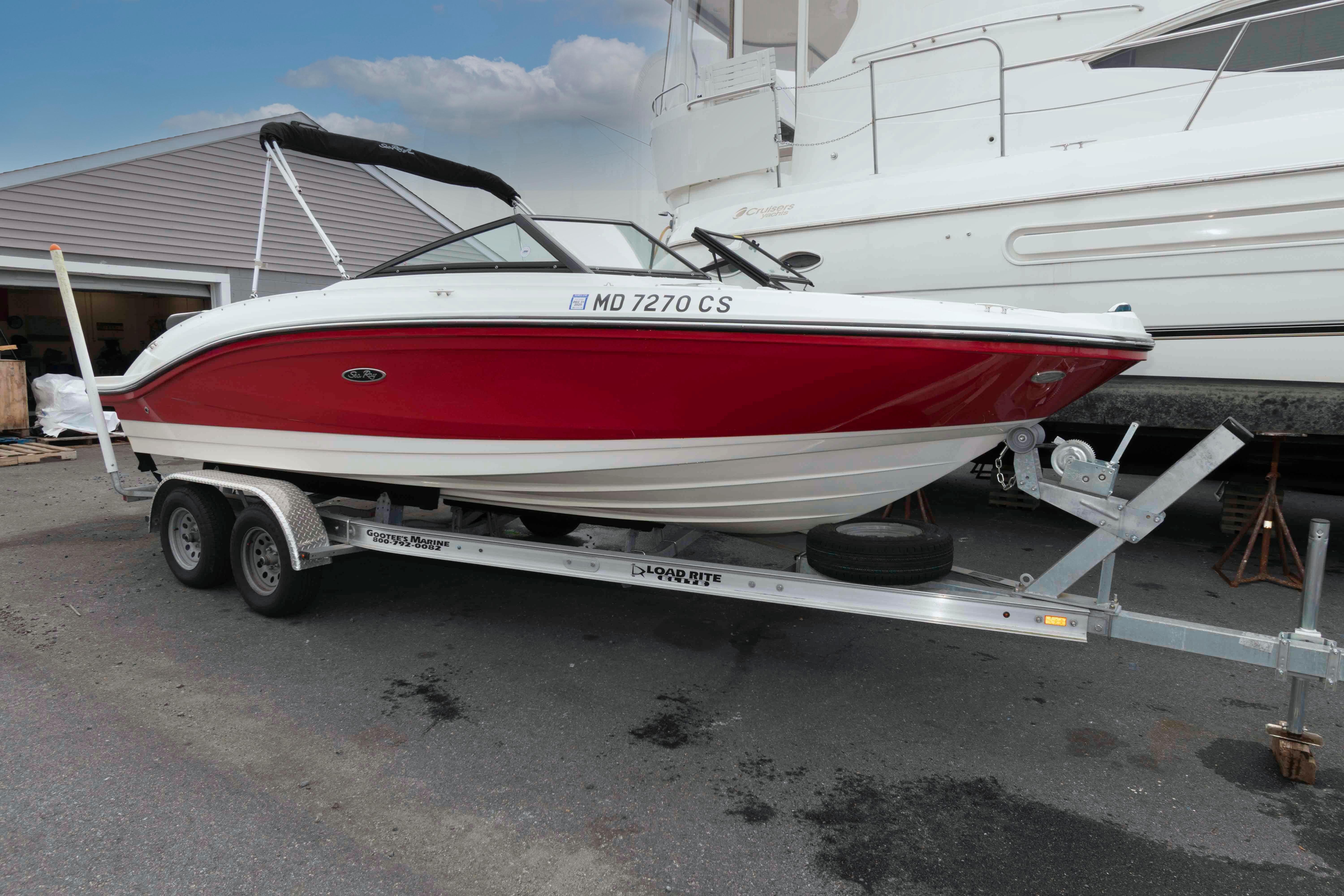 Sea Ray SPX 210 2018 Sea Ray SPX 190 boat in red on a trailer, parked outdoors.