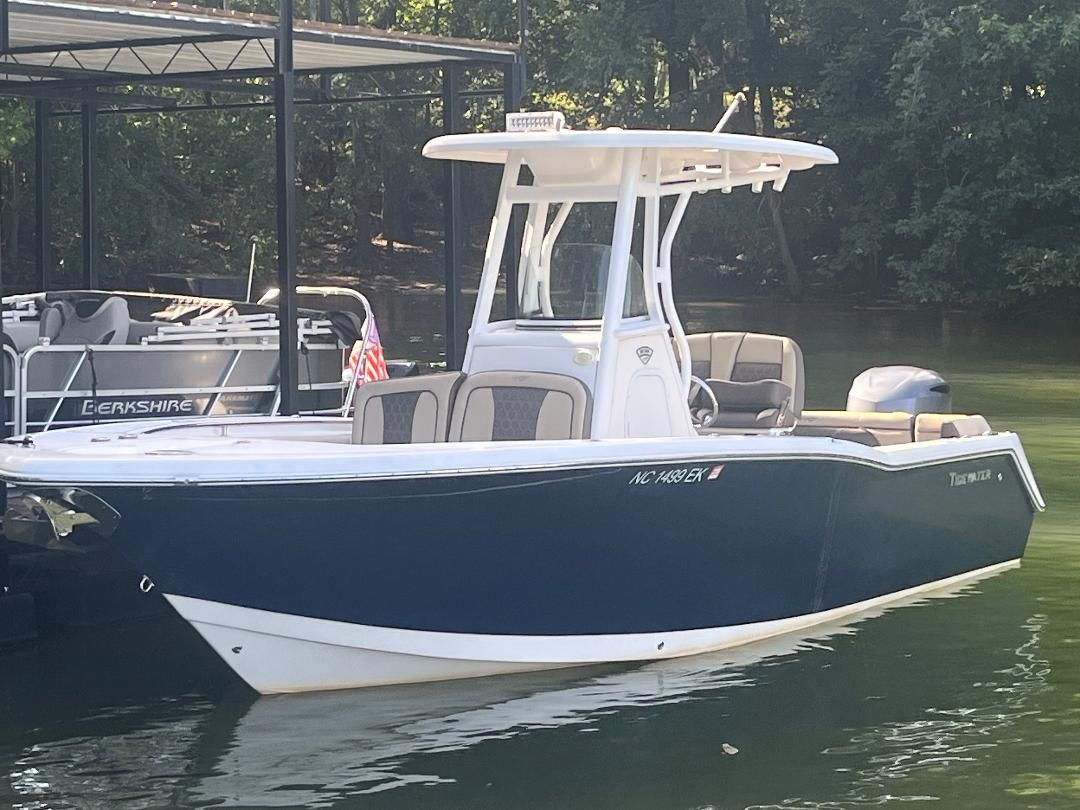 Tidewater 232 2018 Tidewater 232 boat docked on calm water, surrounded by trees.